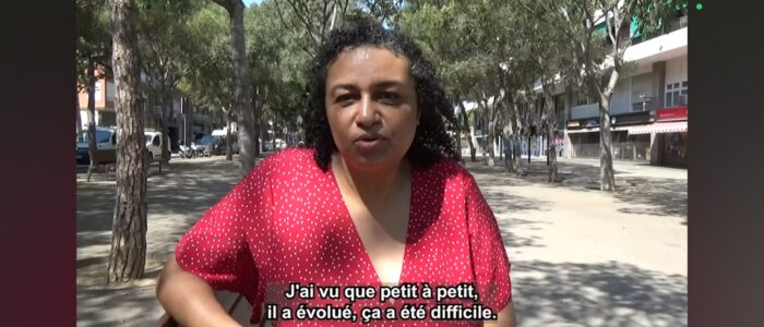 Mujer con vestido rojo de lunares habla sobre salud mental en un parque urbano